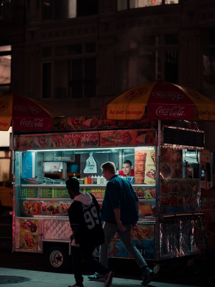 food cart with red umbrellas at dusk