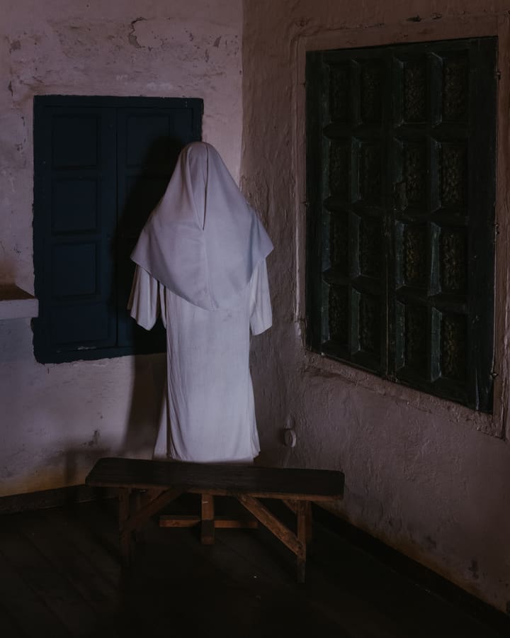 robed figure in monastery room