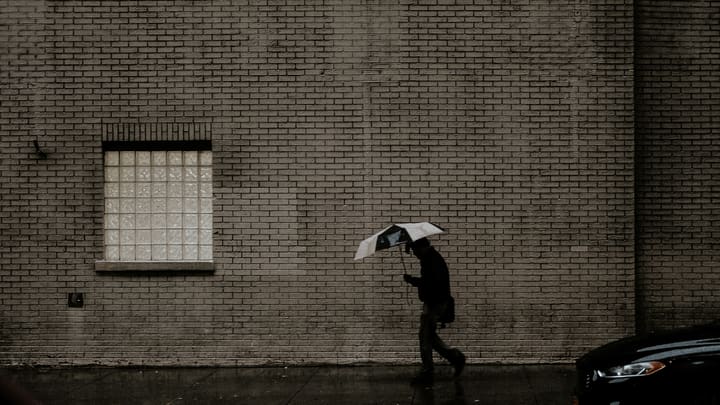 person with umbrella on rainy street