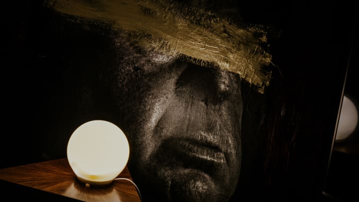 sculpted face with lamp light