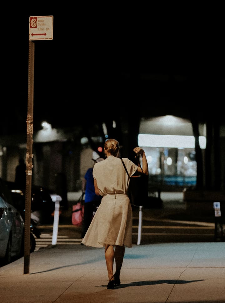 woman walking under streetlight