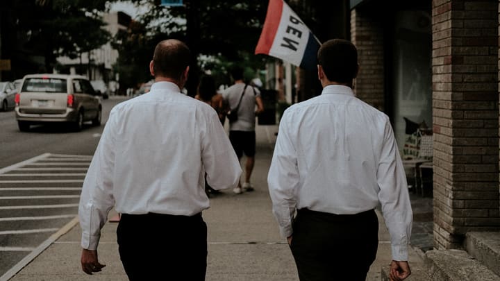 two men walking in white shirts