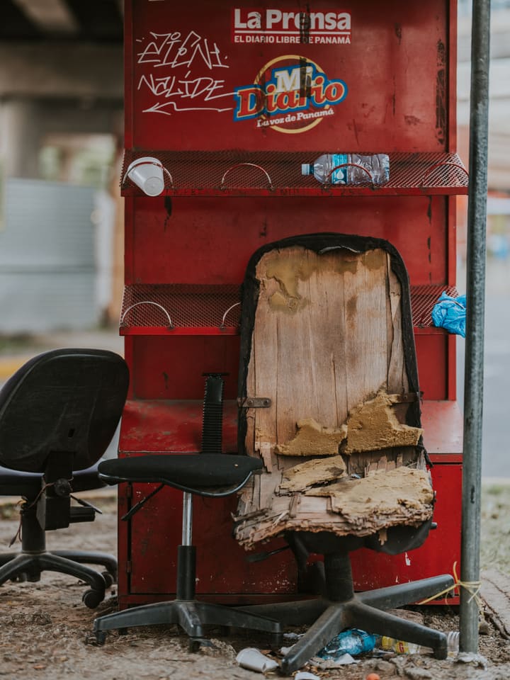 red newsstand with broken chairs