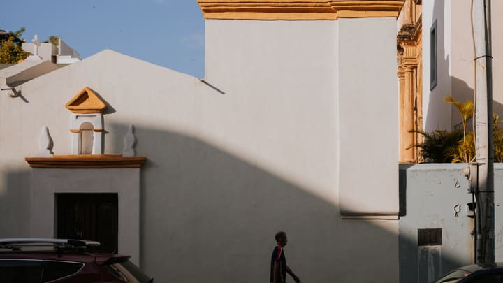 person walking by white church