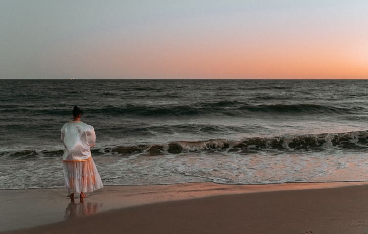 woman walking on beach at sunset
