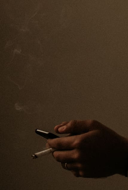hand holding cigarette in dark room