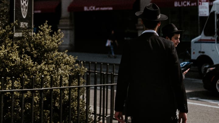 two men walking on city sidewalk