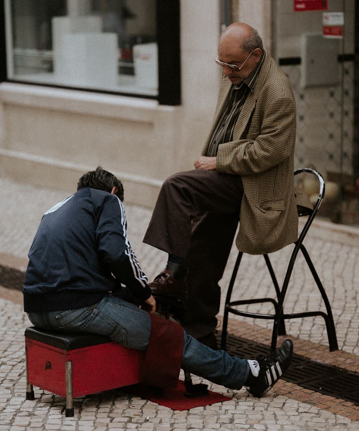 shoeshine man and customer on street