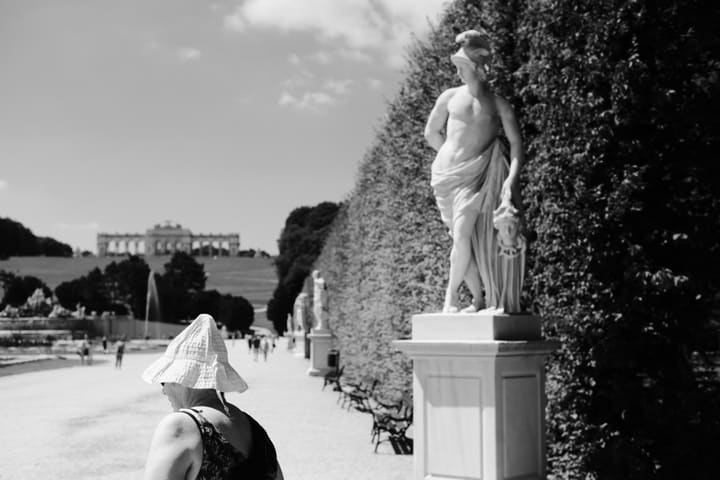 statue in palace garden, woman viewing