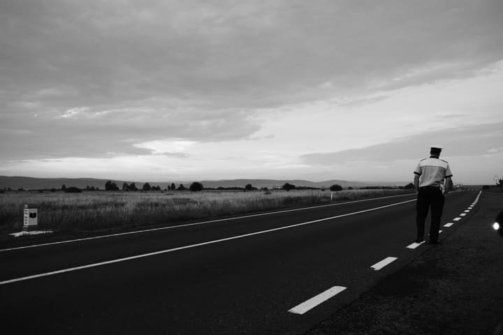 man walking on rural road, black and white