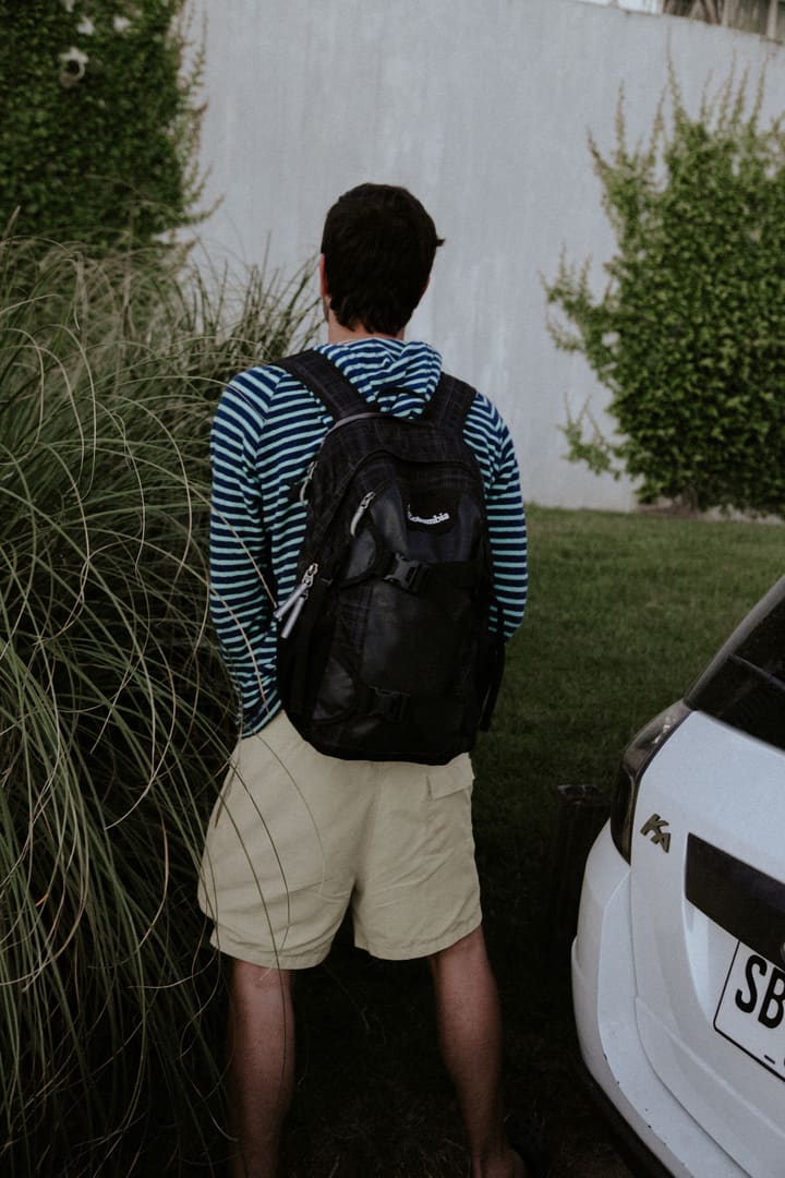 man from behind with backpack, yard