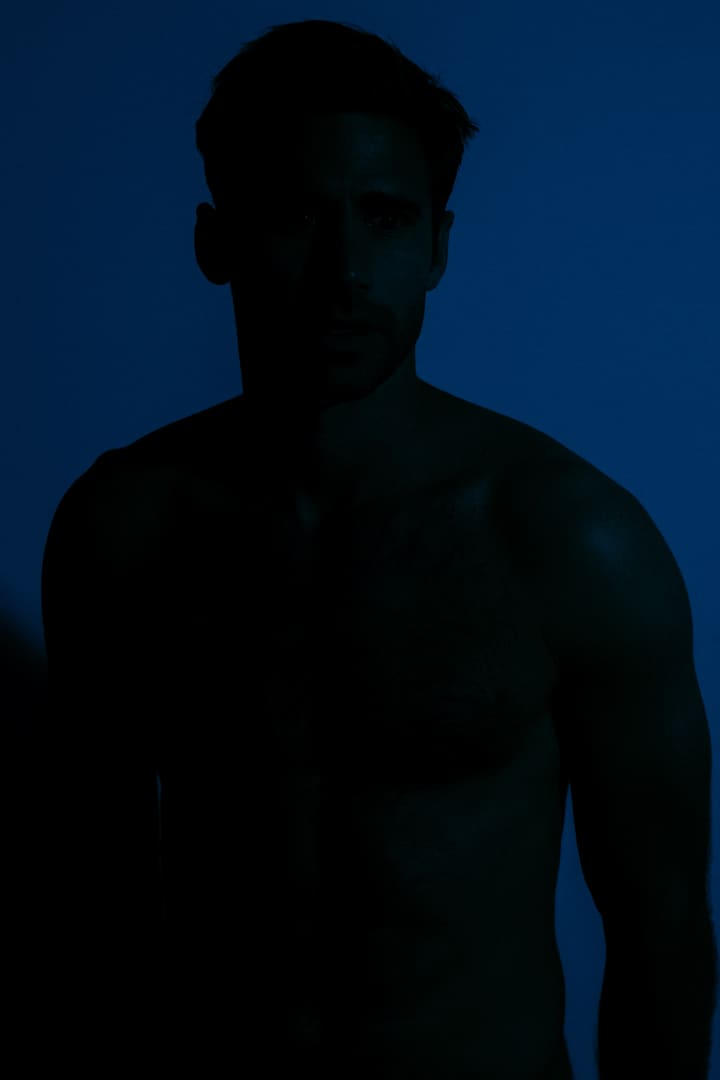 blue-lit male torso portrait
