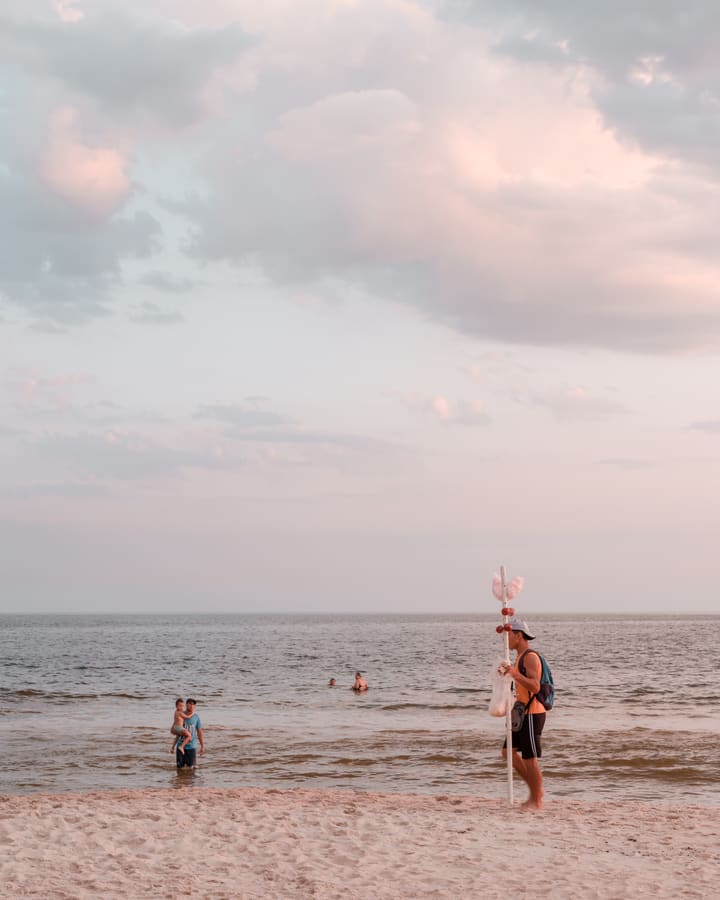 people at beach during pastel dusk